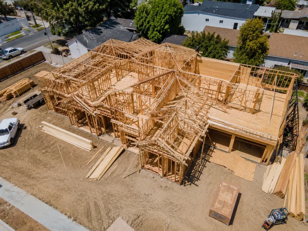 Aerial view of residential rough framing and roof trusses on a Northern California job site